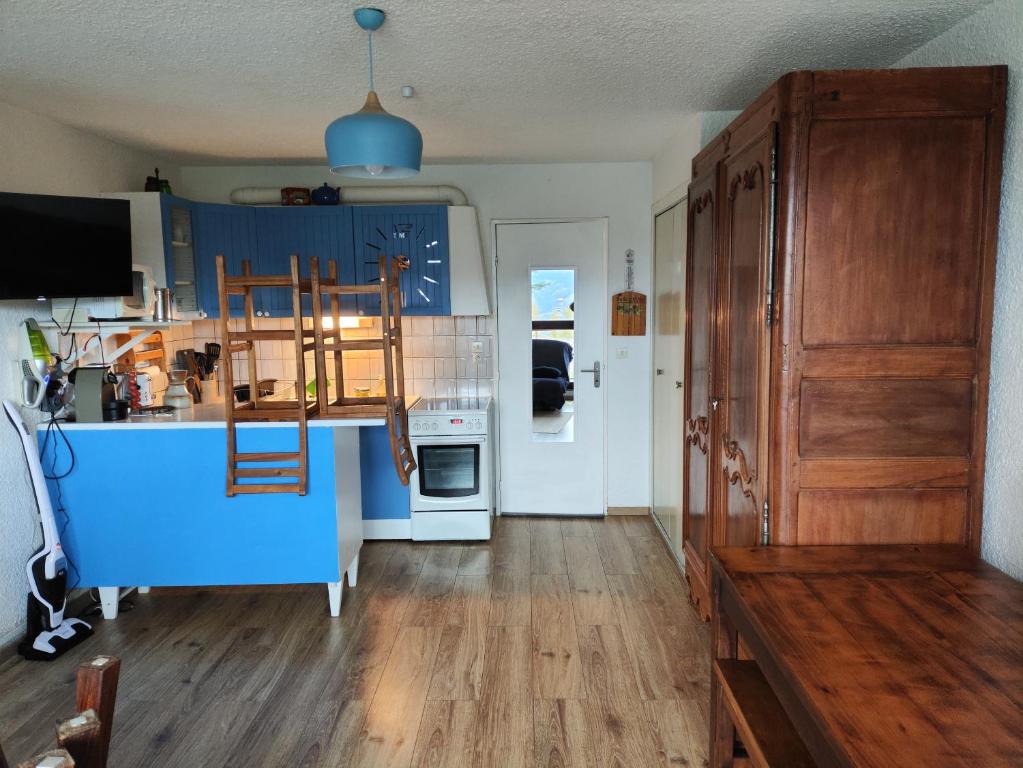 a kitchen with blue cabinets and a counter top at Super Sauze charmant studio en bas des pistes in Enchastrayes