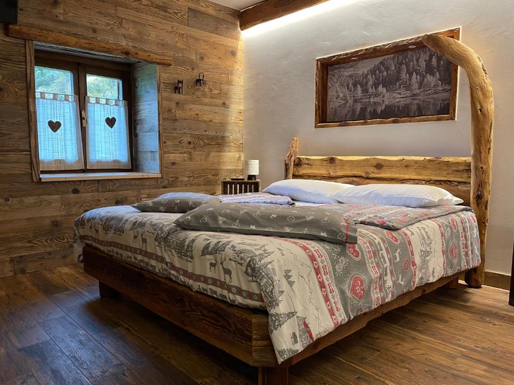 una camera con un letto in una stanza con pareti in legno di Bed and Breakfast Campo Base a Carona