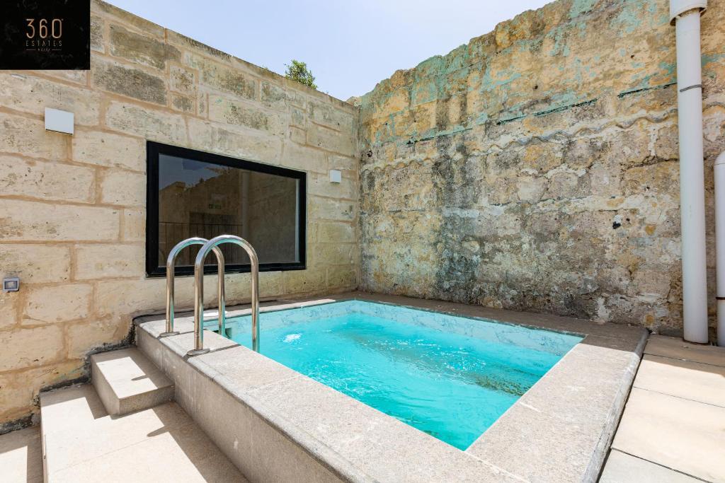 una gran piscina en una pared de ladrillo en Historical Mdina Gem, Lux HOME with Rooftop Pool by 360 Estates en Mdina