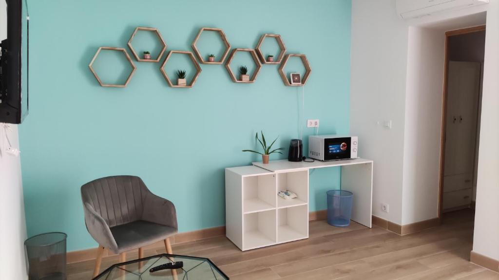 une chambre avec une chaise et un mur bleu dans l'établissement Pensión Alicante Bergez, à Alicante