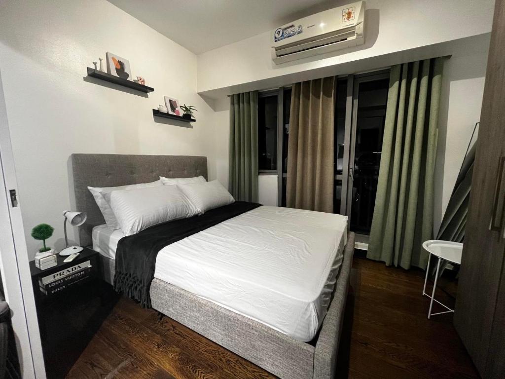 a bedroom with a bed and a air conditioner at Prime Posh Downtown Condo in Manila