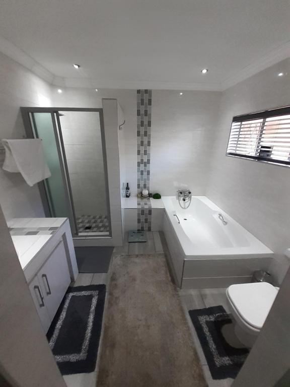 a bathroom with a tub and a toilet and a sink at Just B Zone Guest House in Johannesburg
