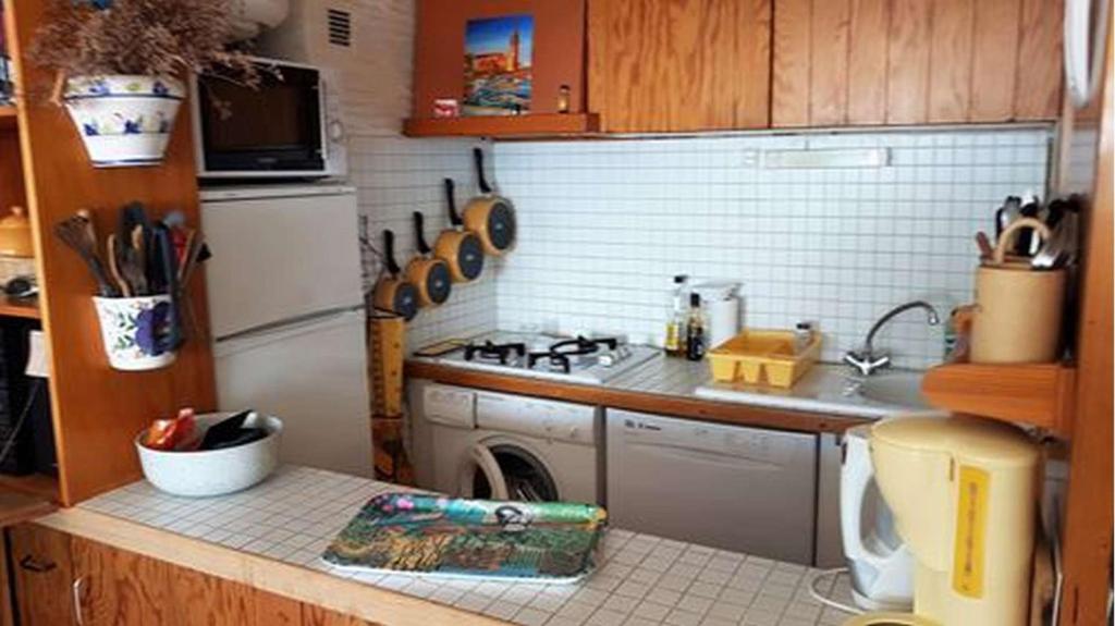 a small kitchen with a stove and a sink at Superbe vue pour ce joli T2 en front de mer -Wifi -Direct Plage-5PC254 in Saint-Cyprien-Plage