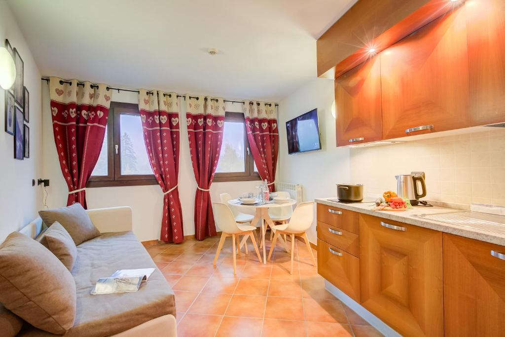 eine Küche mit einem Sofa und einem Tisch in einem Zimmer in der Unterkunft L' Aquila Campo Smith On The Ski Slopes - Happy Rentals in Bardonecchia