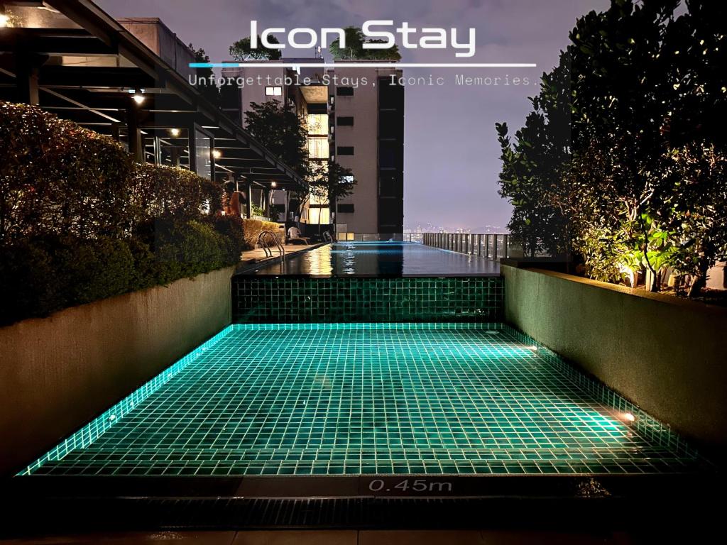 een zwembad met groene lichten op een gebouw bij 2BR Apartment @ Icon City in Petaling Jaya