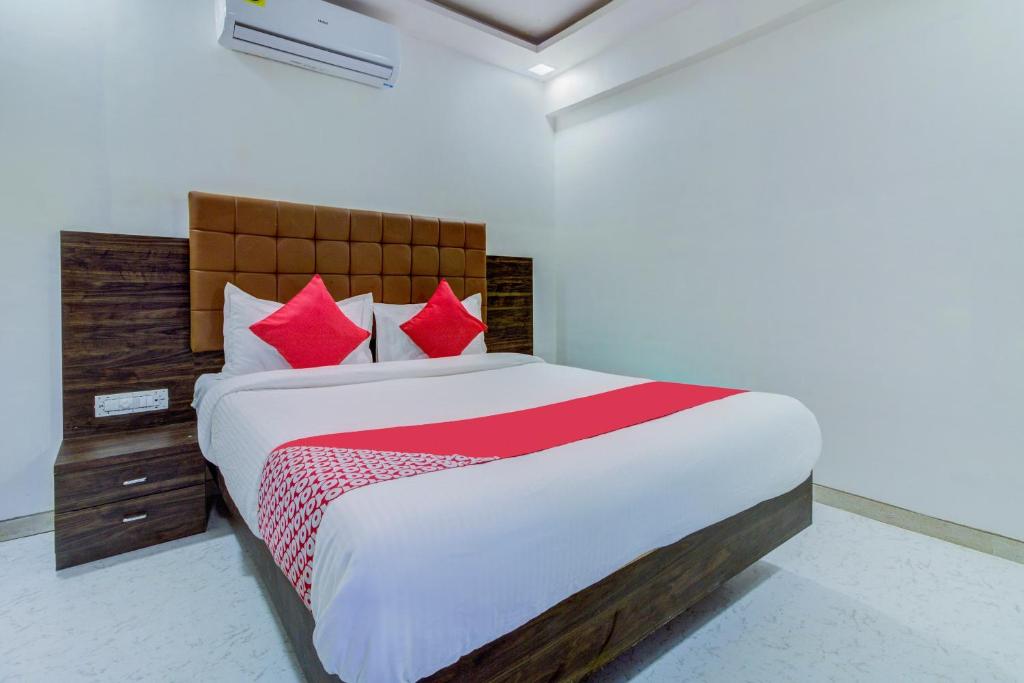 sypialnia z dużym łóżkiem z czerwonymi poduszkami w obiekcie Hotel Golden Palace Lodging and Boarding w mieście Thane