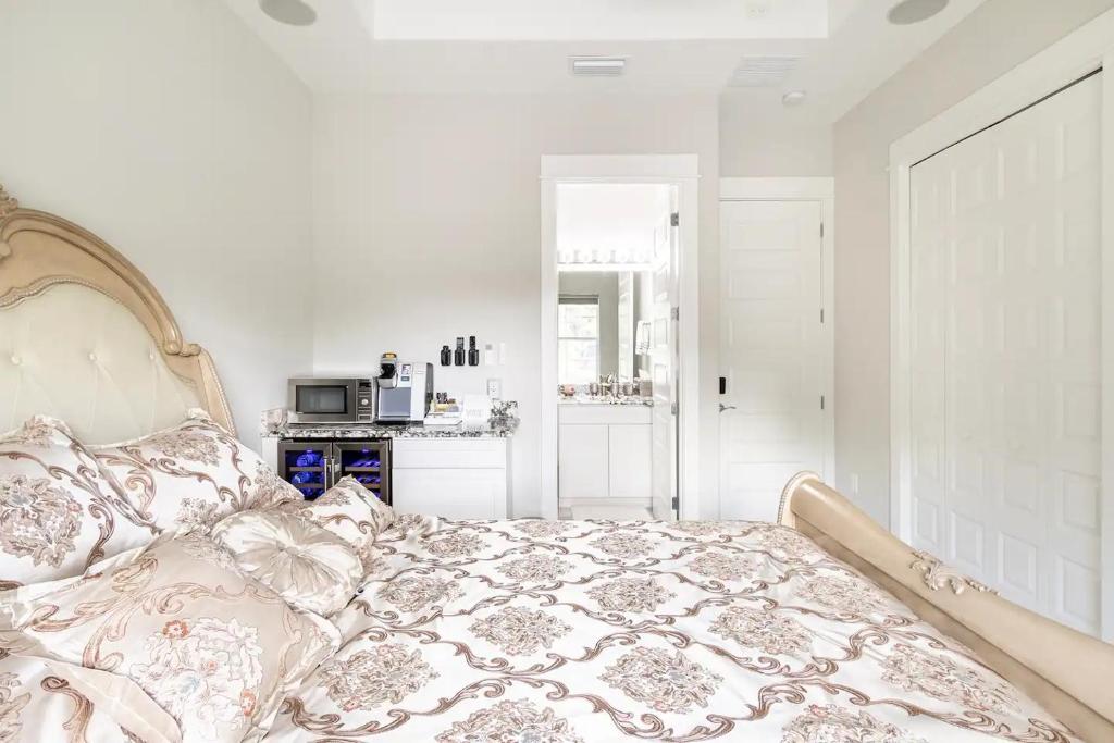 ein weißes Schlafzimmer mit einem Bett mit Tagesdecke in der Unterkunft Voyager in Merritt Island