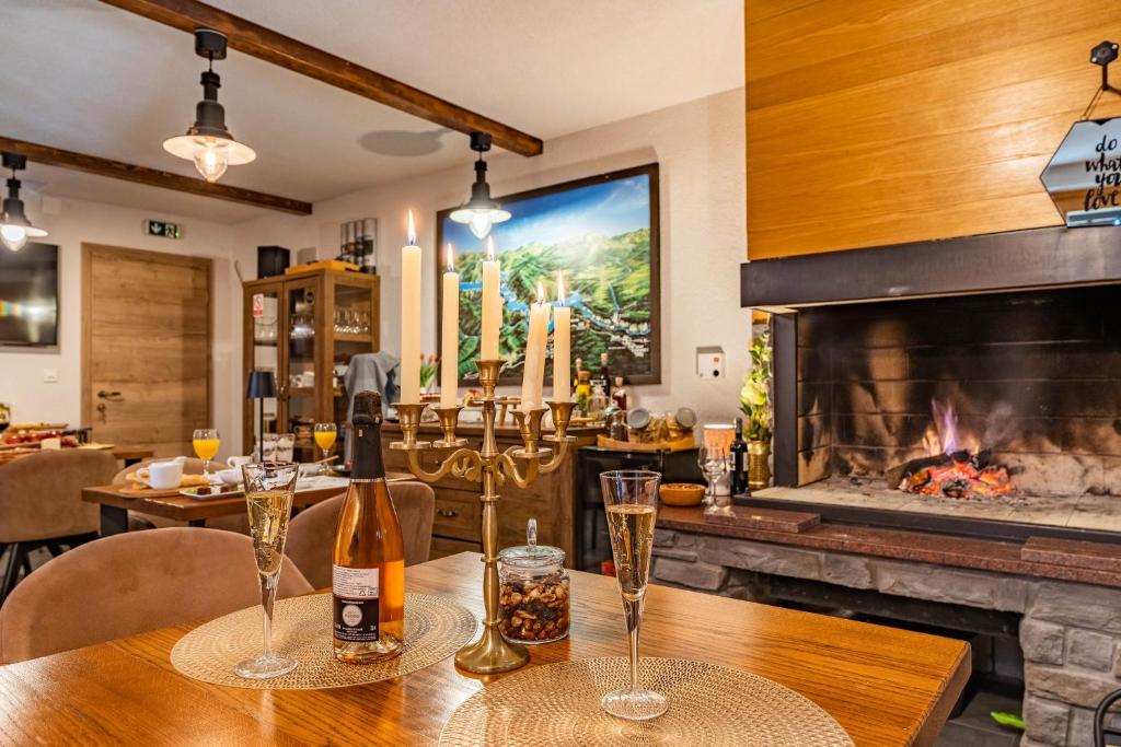 a table with wine glasses and a fireplace at B&B Villa Sumrak Plitvica Rooms in Plitvička Jezera