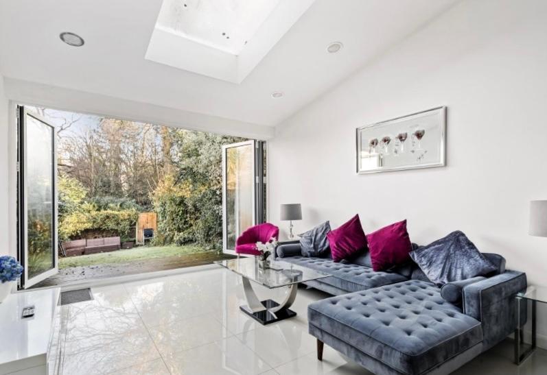 a living room with a couch and a glass table at Weybridge Home in Weybridge