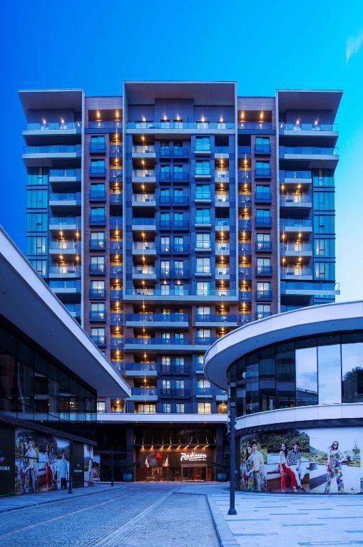 a tall building with lights on in front of it at Radisson Residences Vadistanbul in Istanbul