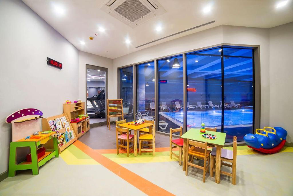 a childrens room with a table and chairs and a pool at Radisson Residences Vadistanbul in Istanbul