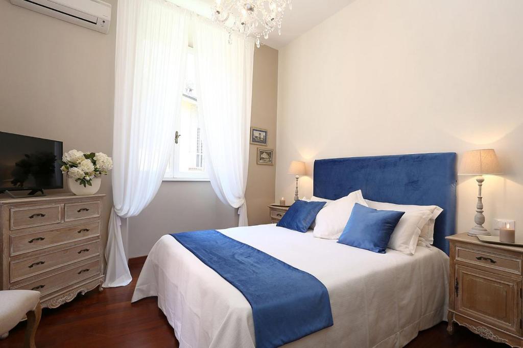 ローマにあるAvignonesi Suitesのベッドルーム(青と白のベッド1台、窓付)