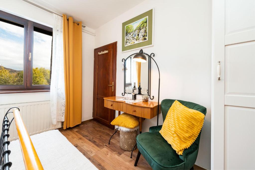 a bathroom with a sink and a chair and a mirror at B&B Villa Sumrak Plitvica in Plitvica selo