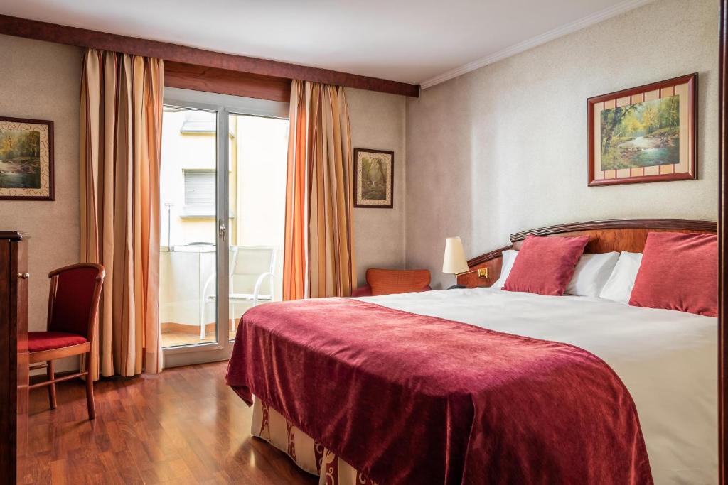 Cette chambre comprend un grand lit et une fenêtre. dans l'établissement ALEGRIA President, à Andorre-la-Vieille