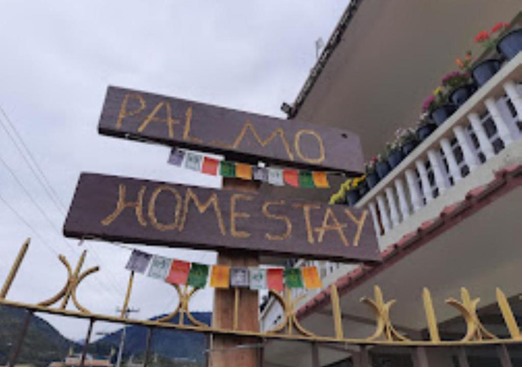 un panneau pour un séjour chez l'habitant sur le côté d'un bâtiment dans l'établissement PAL_MO Homestay Arunachal Pradesh, à Tawang