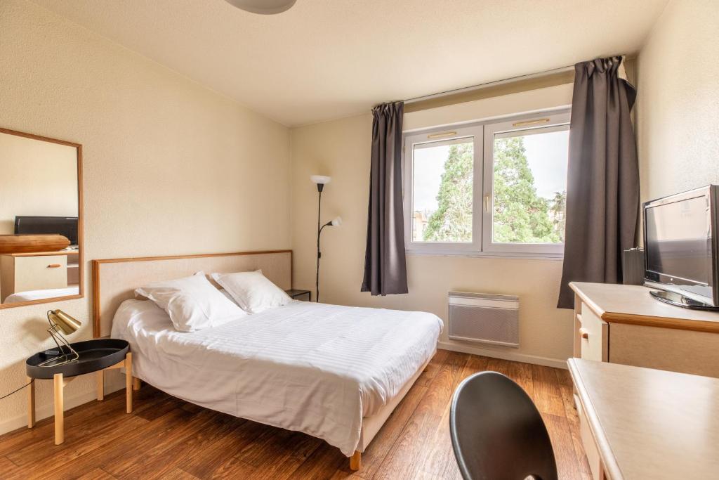 une chambre d'hôtel avec un lit et une fenêtre dans l'établissement Résidence Les Dômes, à Royat