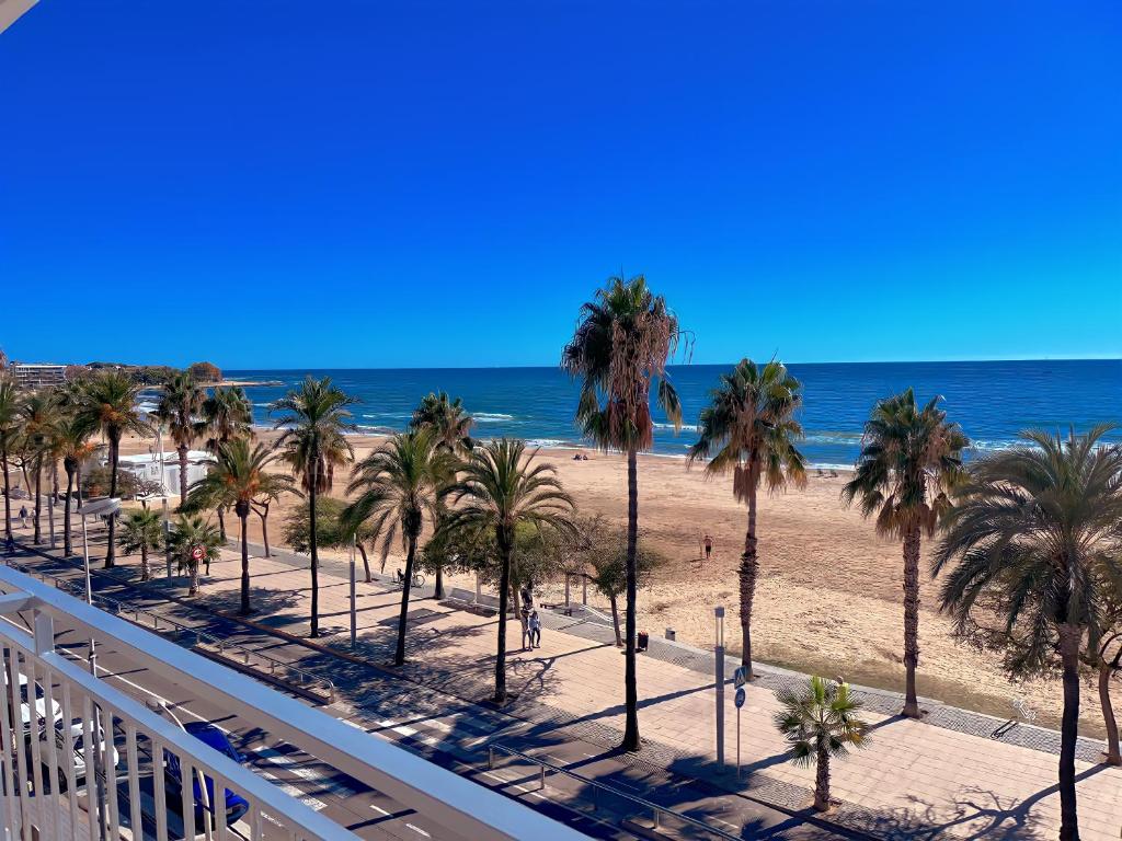 een uitzicht op een strand met palmbomen en de oceaan bij For a Stay Horizonte Mar in Cambrils