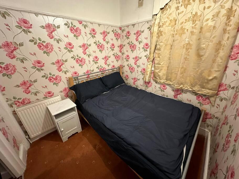 倫敦的住宿－Sweet dream 3，一张小床,位于带花卉壁纸的房间