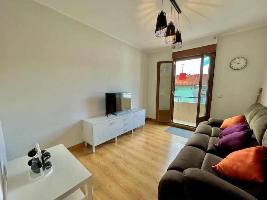 een woonkamer met een bank en een tv bij Ostadar etxea Centrico apartamento reformado in Bermeo