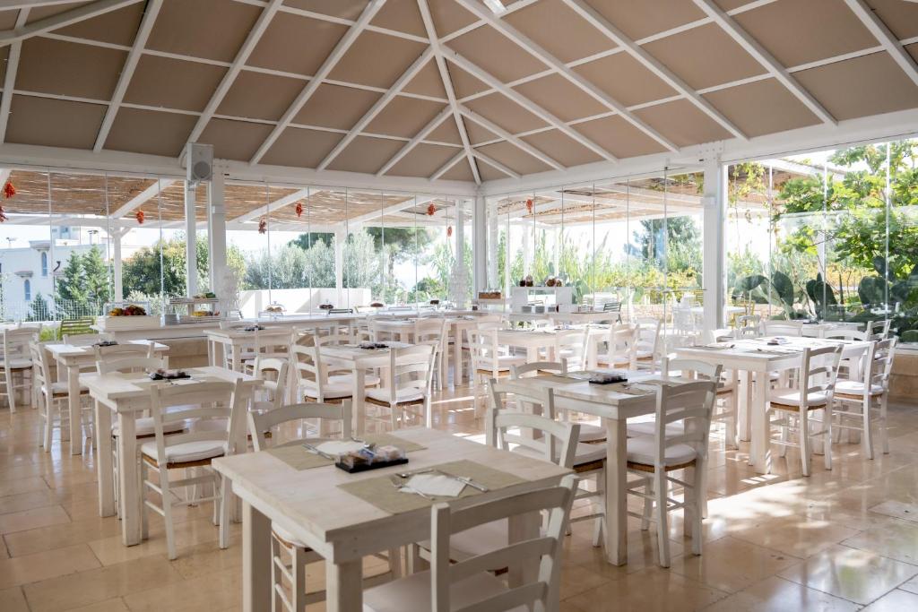 a dining room with white tables and white chairs at San Lorenzo Boutique Hotel & SPA in Polignano a Mare