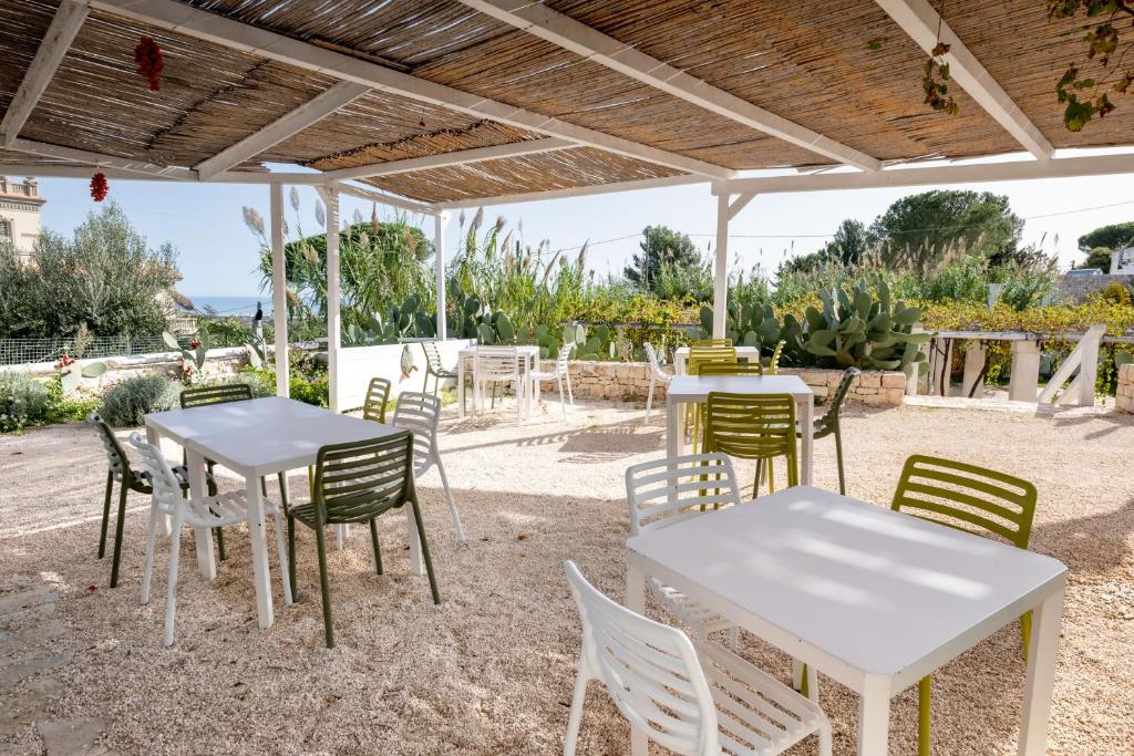 a group of tables and chairs under a pavilion at San Lorenzo Boutique Hotel & SPA in Polignano a Mare