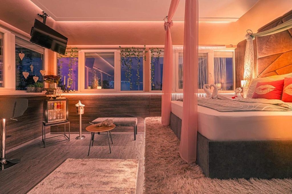 ein Schlafzimmer mit einem Bett und einem Schreibtisch in einem Zimmer in der Unterkunft Mártoni Resort & Restaurant in Szigetszentmárton