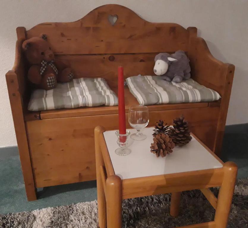 a wooden bed with a table and a red candle on it at Appartement Tilia - Avoriaz in Avoriaz
