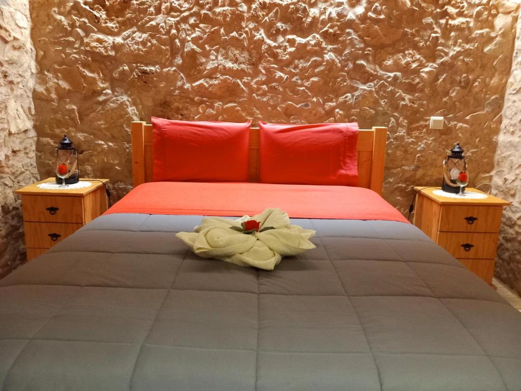 Carregã Water mill في بينيلا: غرفة نوم بسرير ومخدات حمراء وطاولتين