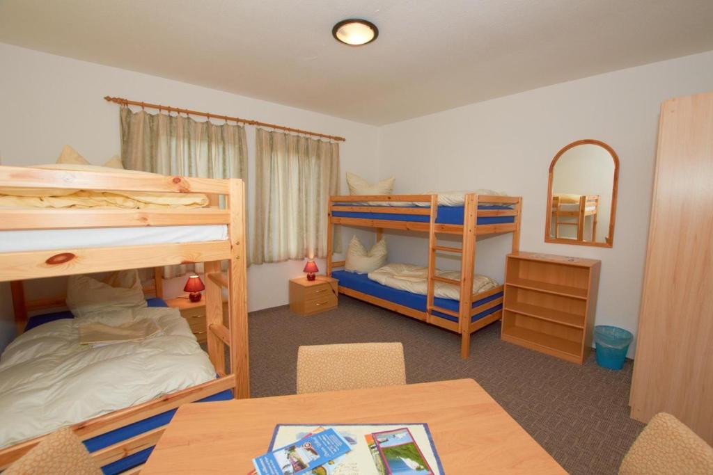 a room with two bunk beds and a table at Familienzimmer-mit-Gemeinschaftsbad-fuer-4-Personen-H5Zi4 in Rappin