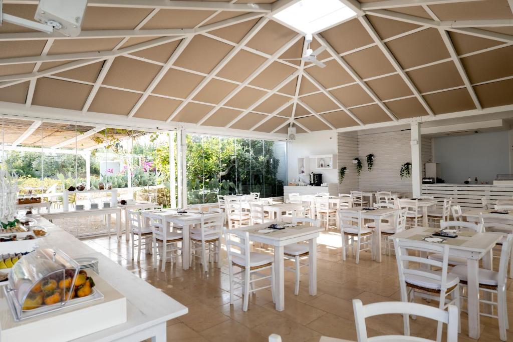a dining room with white tables and white chairs at San Lorenzo Boutique Hotel & SPA in Polignano a Mare