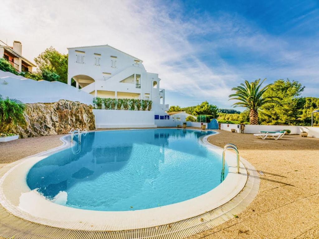 a villa with a swimming pool in front of a house at Peaceful Flat Menorca Sea And Wifi in Son Parc