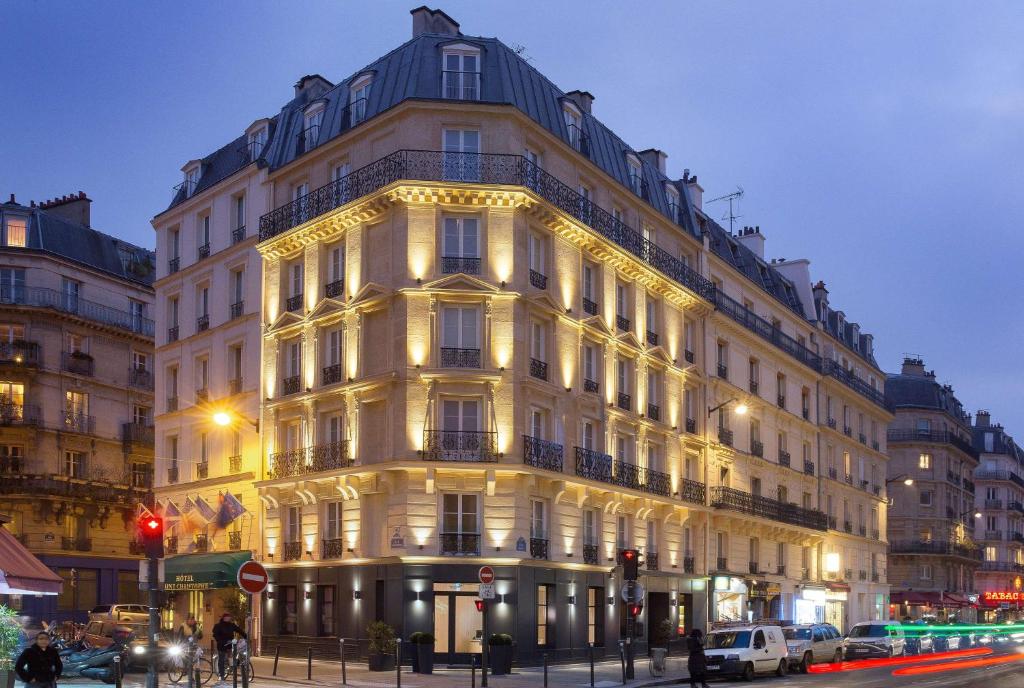 een groot wit gebouw in een stadsstraat 's nachts bij Best Western Quartier Latin Pantheon in Parijs