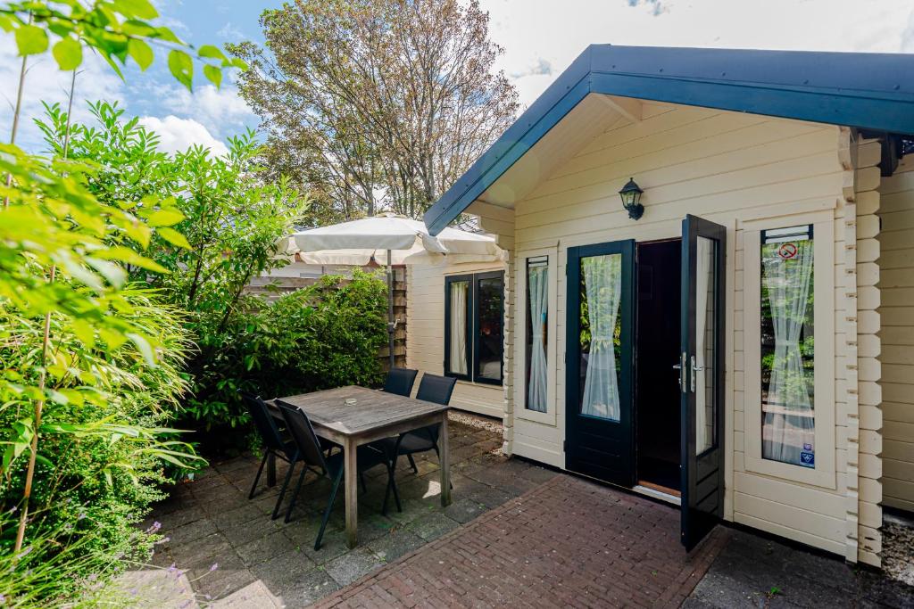 un patio con mesa y sillas frente a una casa en Chalet Zandvoort, en Zandvoort