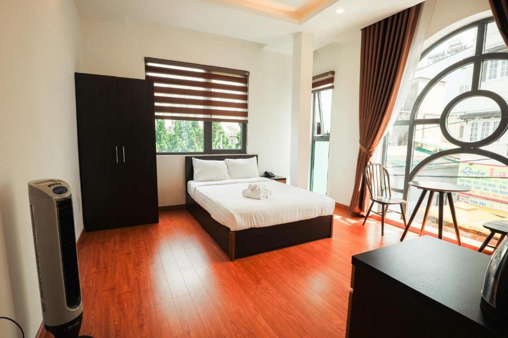 a bedroom with a bed and a tv and a window at TTR Midtown View Hotel in Da Lat