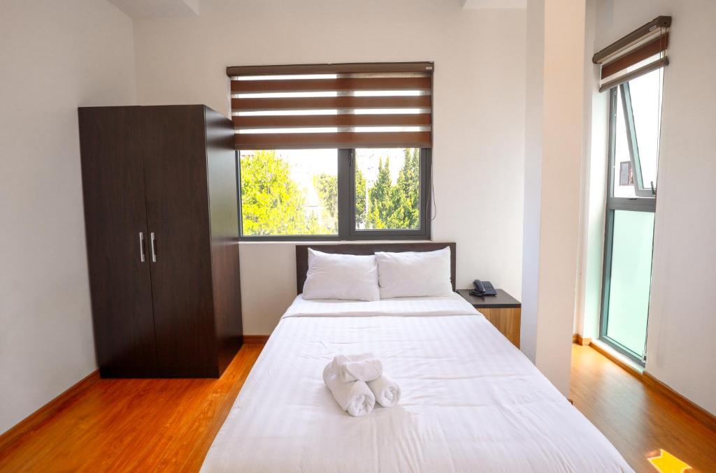 a bedroom with a bed with a stuffed animal on it at TTR Midtown View Hotel in Da Lat