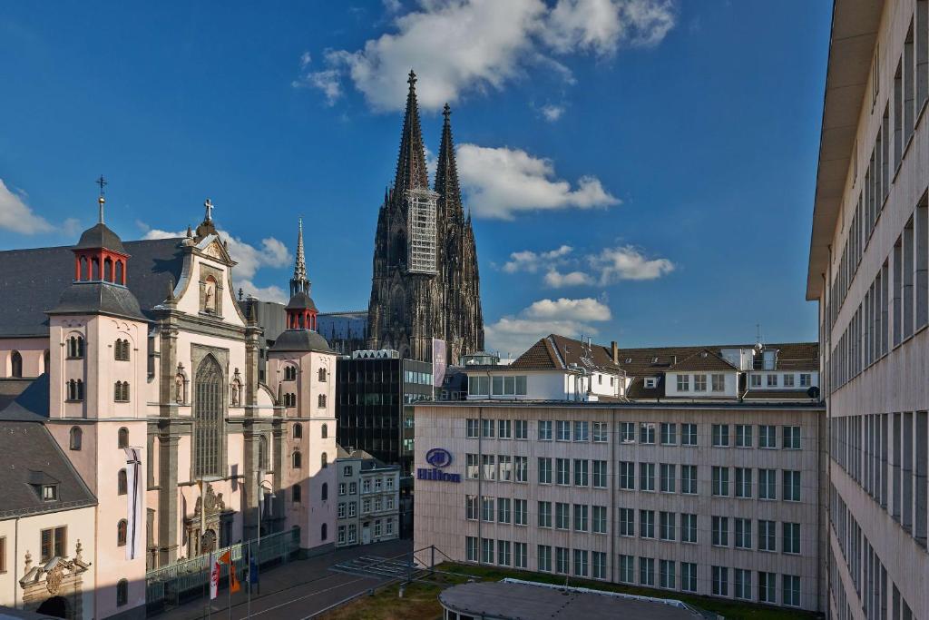 a view of a city with a clock tower and buildings at Hilton Cologne in Cologne