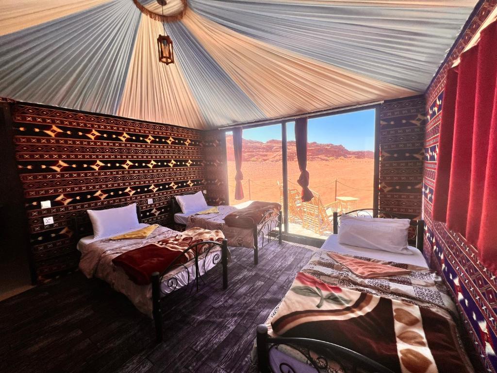 a room with beds and a view of the desert at Wadi Rum Sky Tours & Camp in Wadi Rum
