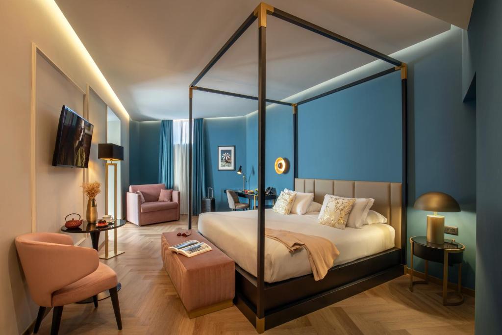 a bedroom with a canopy bed and a chair at The Major Hotel in Rome