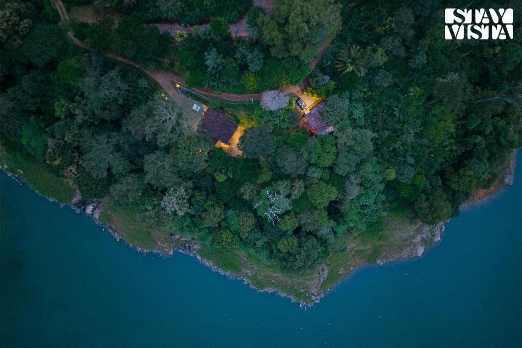 an aerial view of a house on a island next to the water at StayVista at Cave Song with Bonfire & Complimentary Breakfast in Idukki