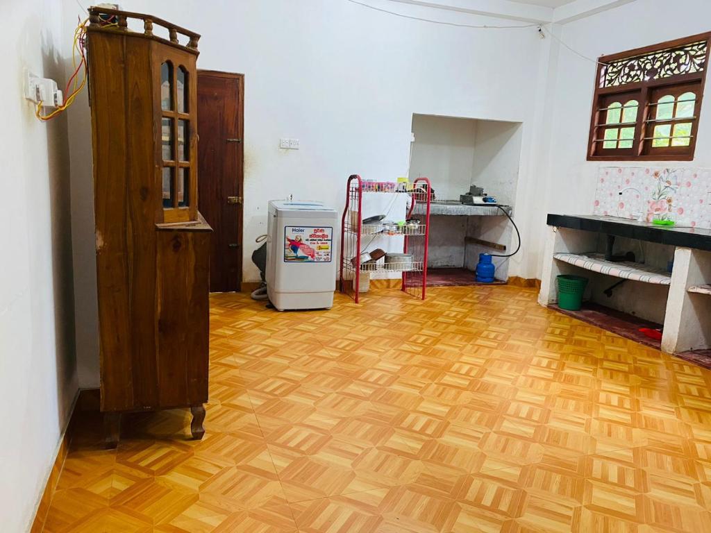 a room with a wooden floor and a refrigerator at Kumara villa in Hikkaduwa