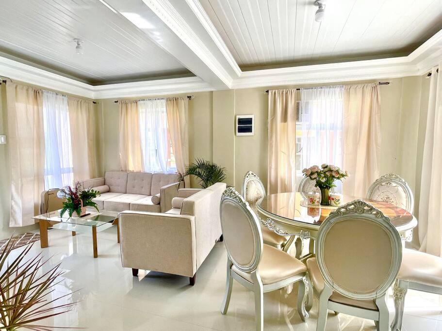 sala de estar con sofá, mesa y sillas en Camella Home Greta Model Rental in Bacolod en Bacólod