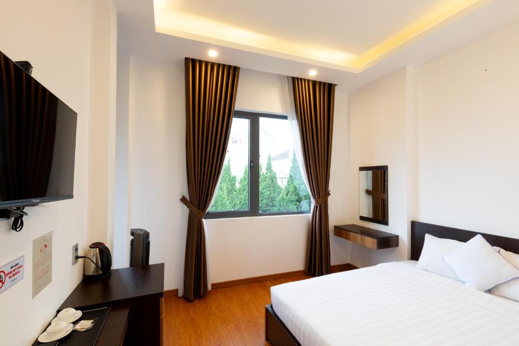 a hotel room with a bed and a window at TTR Midtown View Hotel in Da Lat