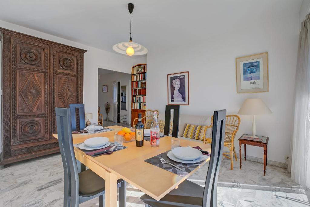 ein Esszimmer mit einem Holztisch und Stühlen in der Unterkunft Appartement Le Fabiola - Happy Rentals in Antibes