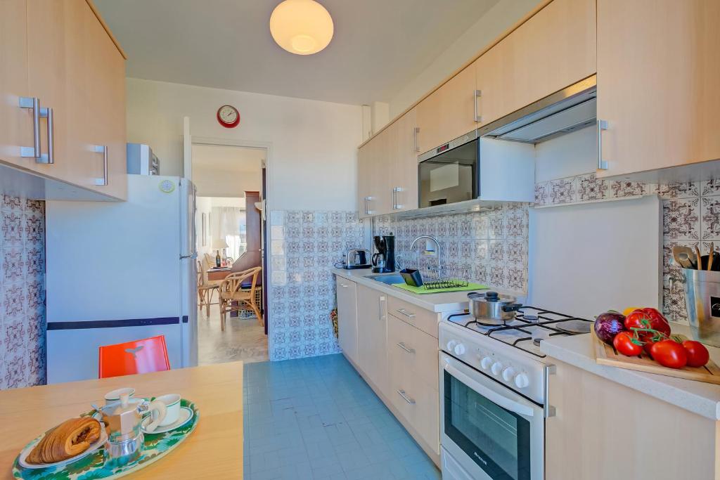 eine Küche mit weißen Schränken und einem Herd mit Backofen in der Unterkunft Appartement Le Fabiola - Happy Rentals in Antibes
