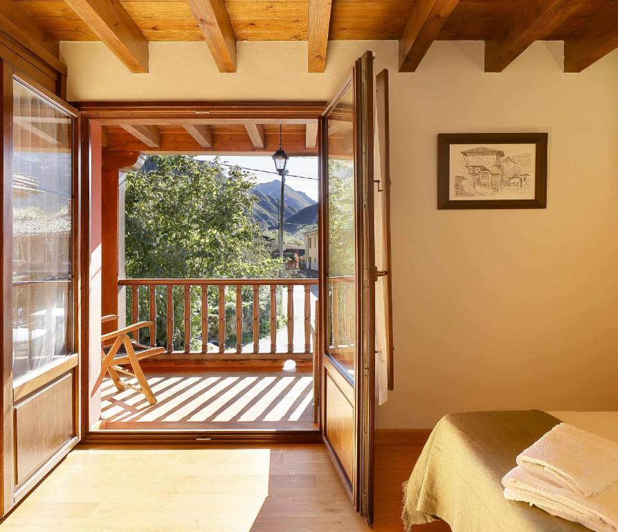 1 dormitorio con una puerta que da a un balcón en Casa Celis 1 Espinaredo, en Espinaredo