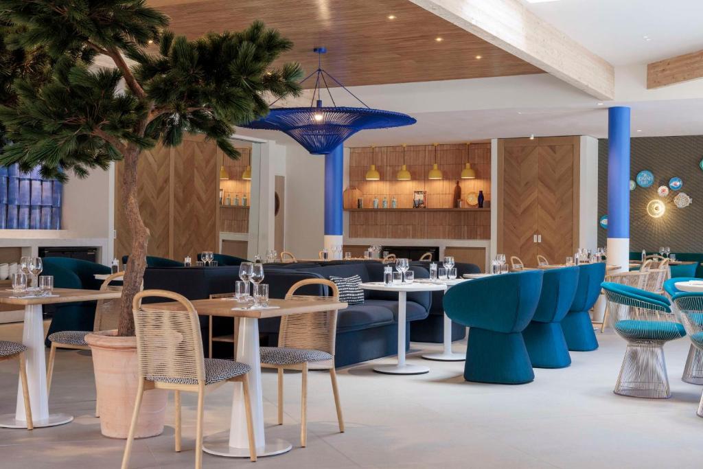 a dining room with tables and chairs and a restaurant at Hilton Garden Inn Marseille Provence Airport in Marignane