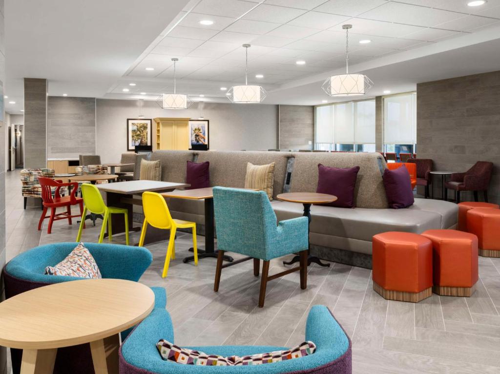 a lobby with colorful chairs and tables and a couch at Home2 Suites by Hilton Orlando South Davenport in Davenport