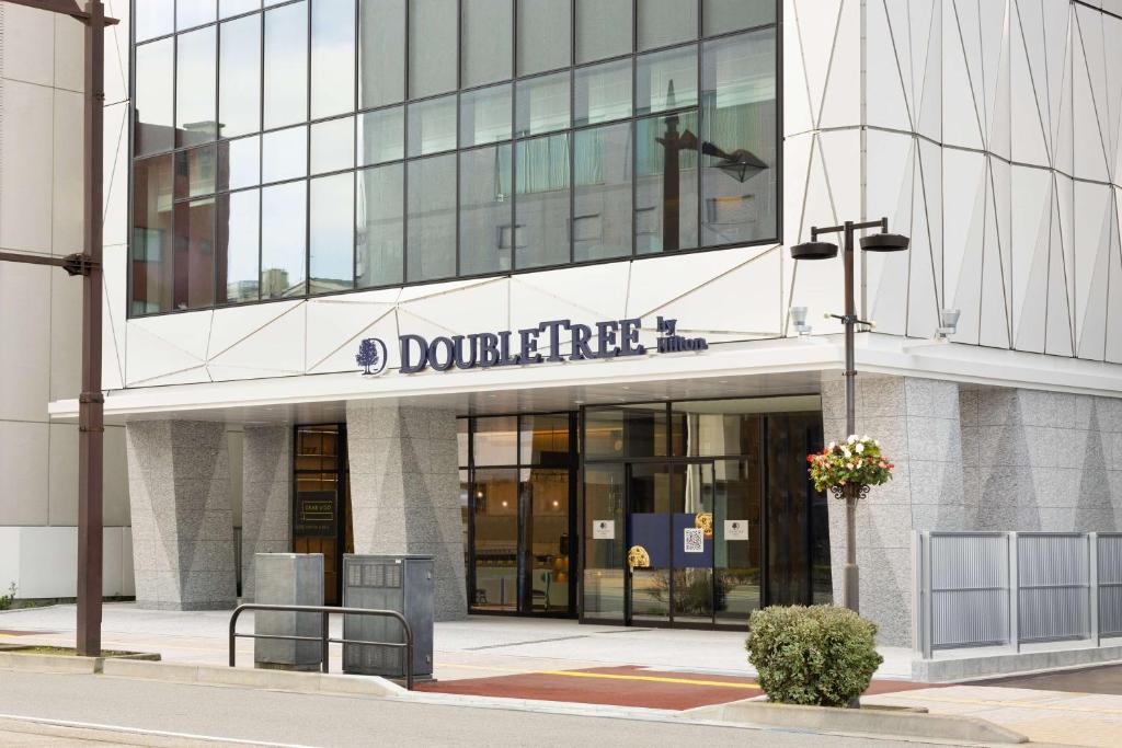 un bâtiment avec un panneau à l'avant dans l'établissement DoubleTree by Hilton Toyama, à Toyama