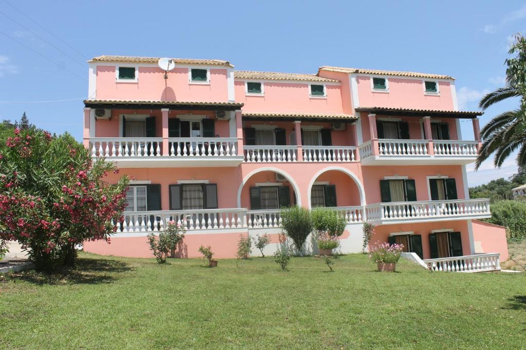 a pink building with a lawn in front of it at Pink House Socrates in Vitalades