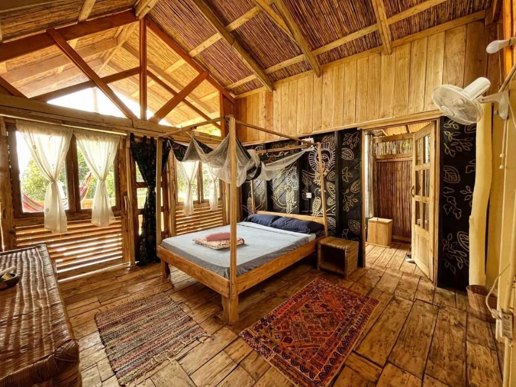 - une chambre avec un lit dans une pièce en bois dans l'établissement Butterfly Space- A Non-Profit Eco-Lodge, à Nkhata Bay